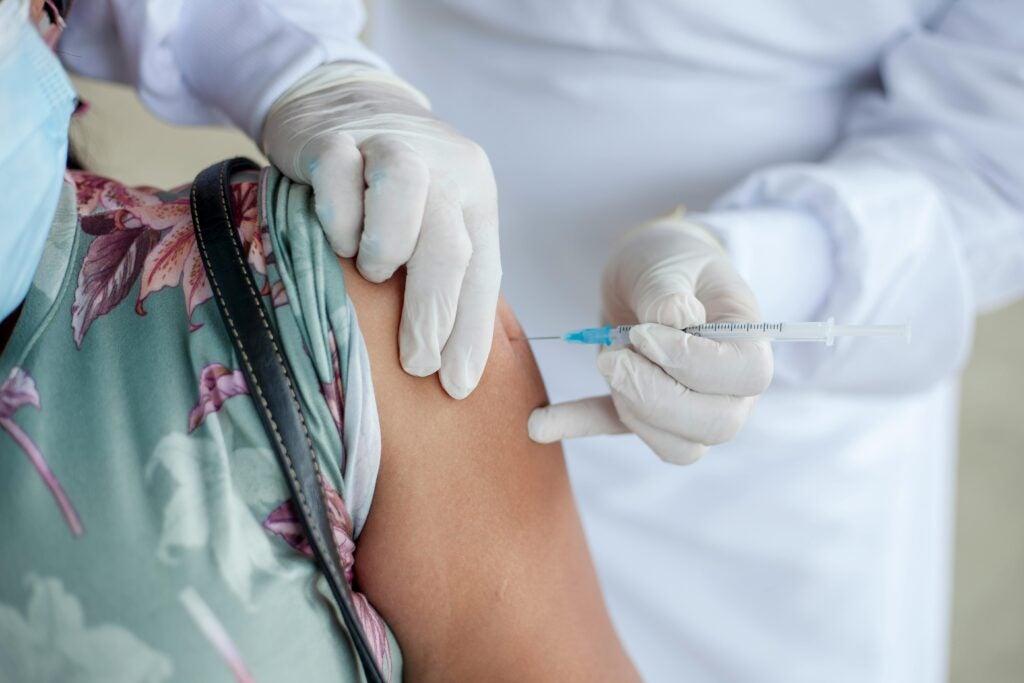 image of clinician administering vaccine to female shoulder